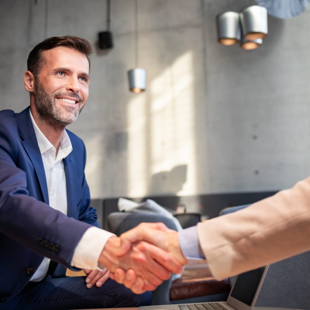 Business people shaking hands during meeting in cafe